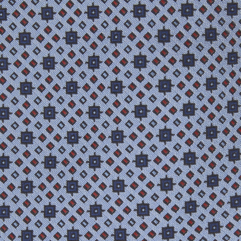 The Turnbull & Asser Sky Blue Geometric Silk Tie features a mid-century dark blue and maroon motif on light blue silk, shown against a white background—ideal for pairing with tailored jackets.