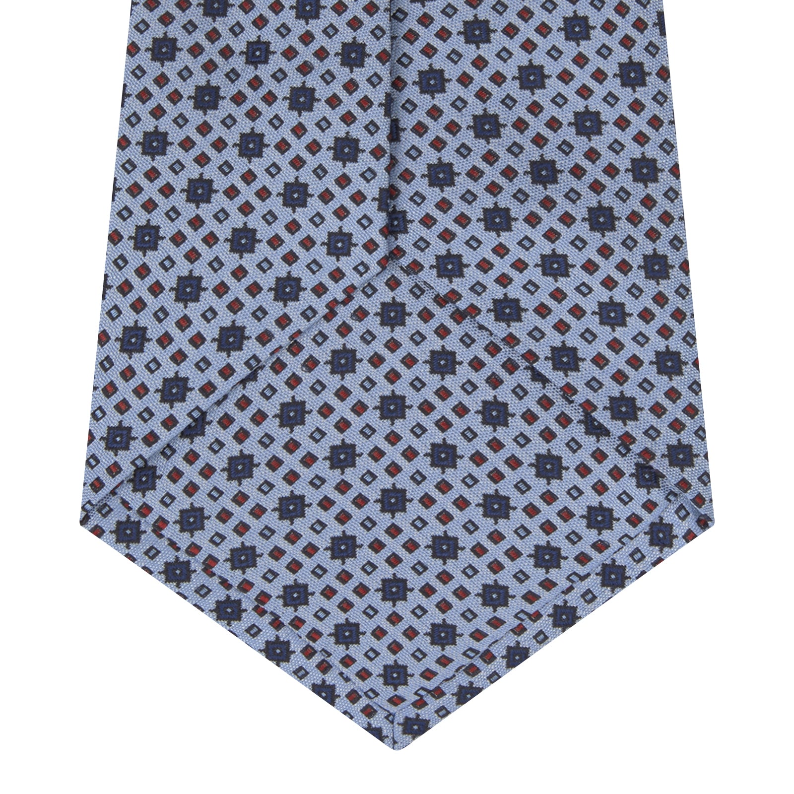 View 4 of product The Turnbull & Asser Sky Blue Geometric Silk Tie features a mid-century dark blue and maroon motif on light blue silk, shown against a white background—ideal for pairing with tailored jackets.