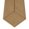 View 4 of product The Gold Flower Mosaic Silk Tie by Turnbull & Asser features an intricate gold jacquard pattern of geometric shapes and floral designs in pink and light brown hues.