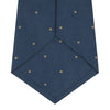 View 4 of product The Deep Turquoise Flower Mosaic Silk Tie by Turnbull & Asser features a jacquard design in blue with a subtle geometric pattern and small gold square accents evenly spaced across the fabric.