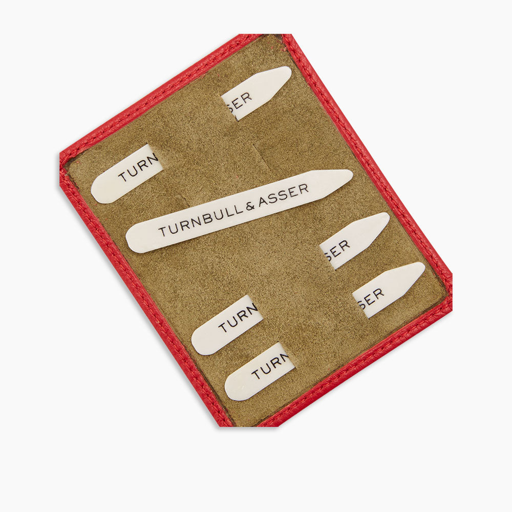 The Bone Collar Stays in Red Leather Lined Olive Suede Tray by Turnbull & Asser securely stores six metal stays, each branded, in a stylish red-edged leather case with organized compartments and an olive suede interior.