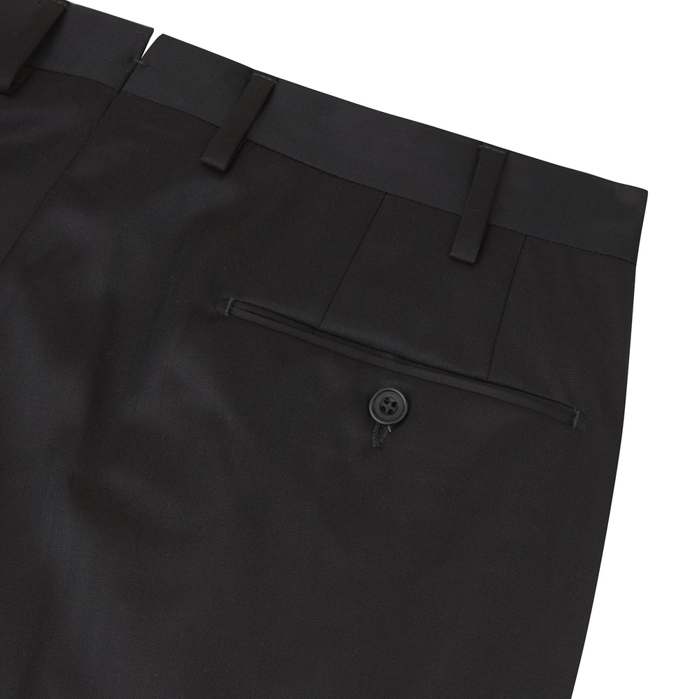The Turnbull & Asser Brown Worsted Wool Pleated Formal Trousers feature belt loops, side pockets, and a button closure, crafted from fine wool and shown against a plain white background.