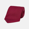 View 1 of product The Turnbull & Asser Burgundy and White Small Spot Printed Silk Tie, shown rolled against a plain white background, is an elegant accessory ideal for the office.