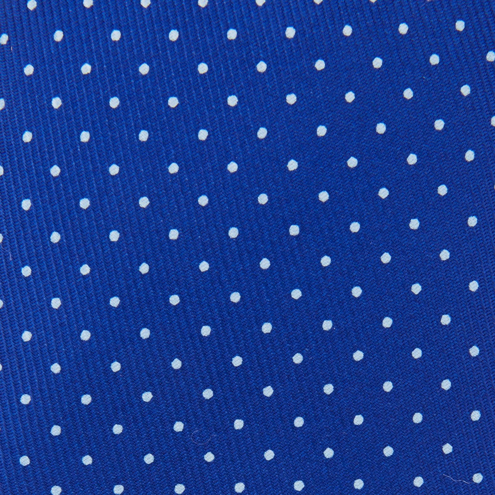 View 3 of product The Turnbull & Asser Royal Blue and White Small Spot Printed Silk Tie, shown rolled on a white background, features a refined spot pattern—ideal for complementing your office shirt.