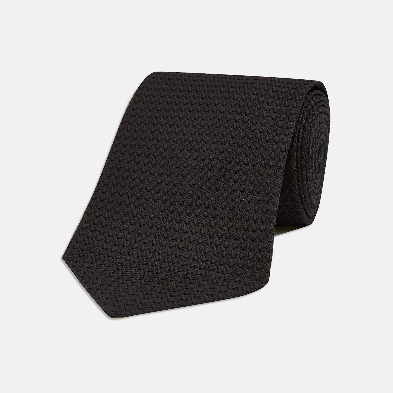View 1 of product The Turnbull & Asser Black Grenadine Silk Tie features a refined textured look and dimensional stability thanks to its subtle grenadine weave, shown here on a white background.