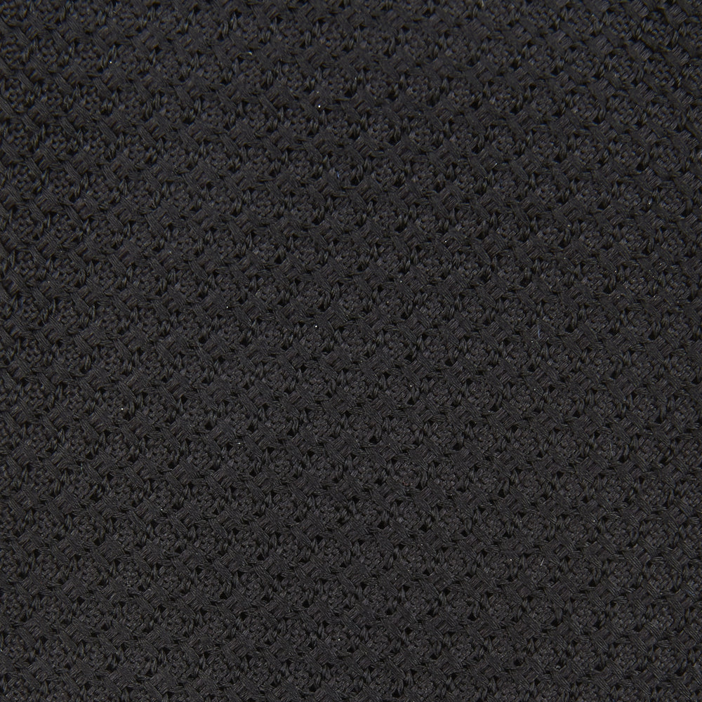The Slim Black Grenadine Silk Tie by Turnbull & Asser, featuring a unique textured weave, is rolled up and displayed against a plain white background.