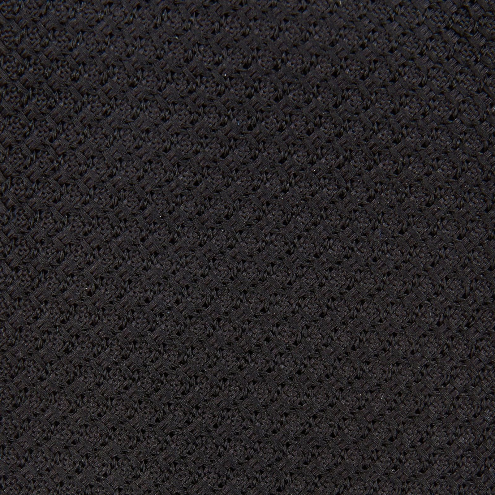 View 3 of product The Turnbull & Asser Black Grenadine Silk Tie features a refined textured look and dimensional stability thanks to its subtle grenadine weave, shown here on a white background.