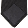 View 4 of product The Slim Black Grenadine Silk Tie by Turnbull & Asser, featuring a unique textured weave, is rolled up and displayed against a plain white background.