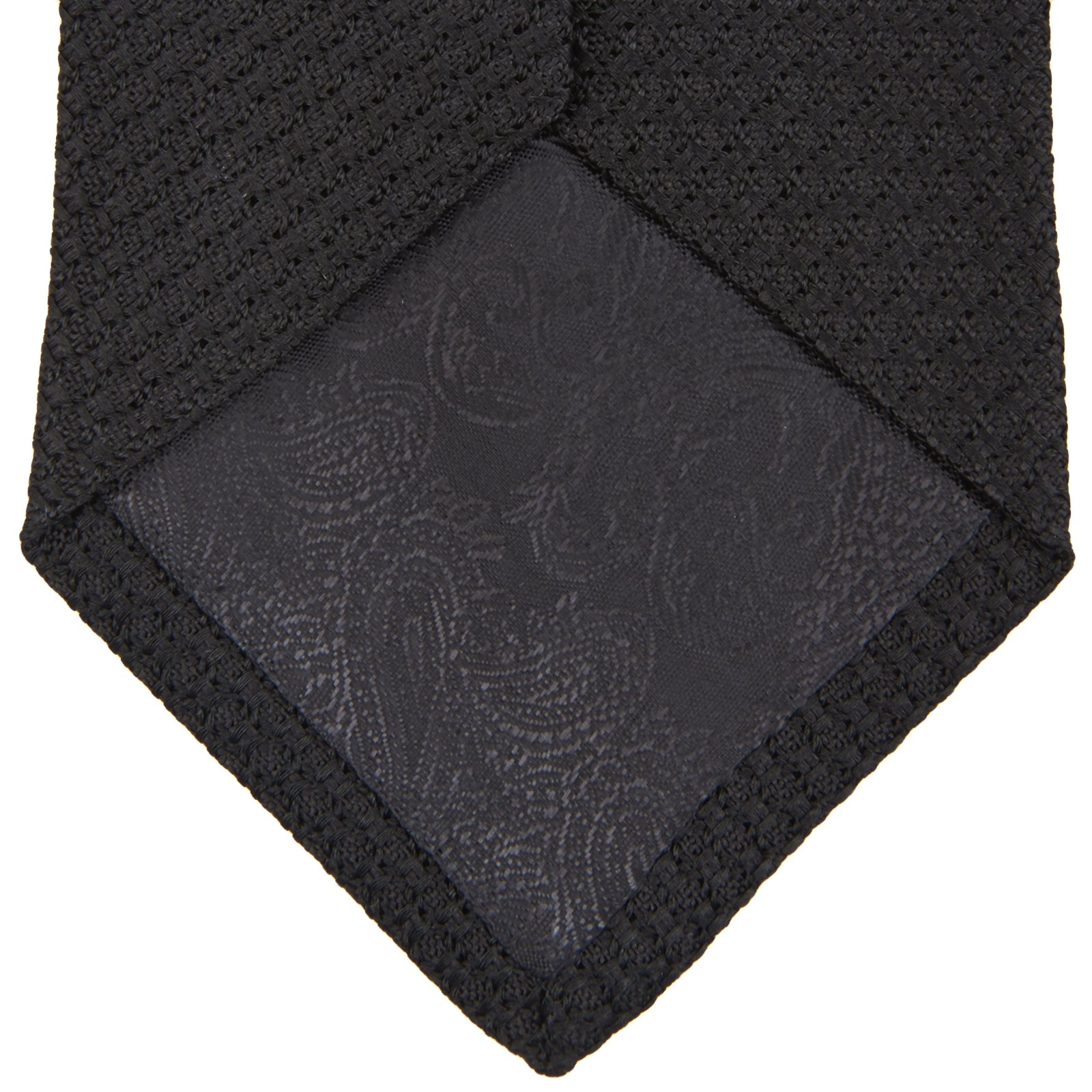 View 3 of product The Turnbull & Asser Long Black Grenadine Silk Tie features a subtle woven pattern and knitted appearance, shown rolled at one end against a plain white background.