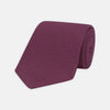 View 1 of product The Turnbull & Asser Wine Grenadine Silk Tie, featuring a textured weave in dark purple, is displayed rolled-up on a plain white background.