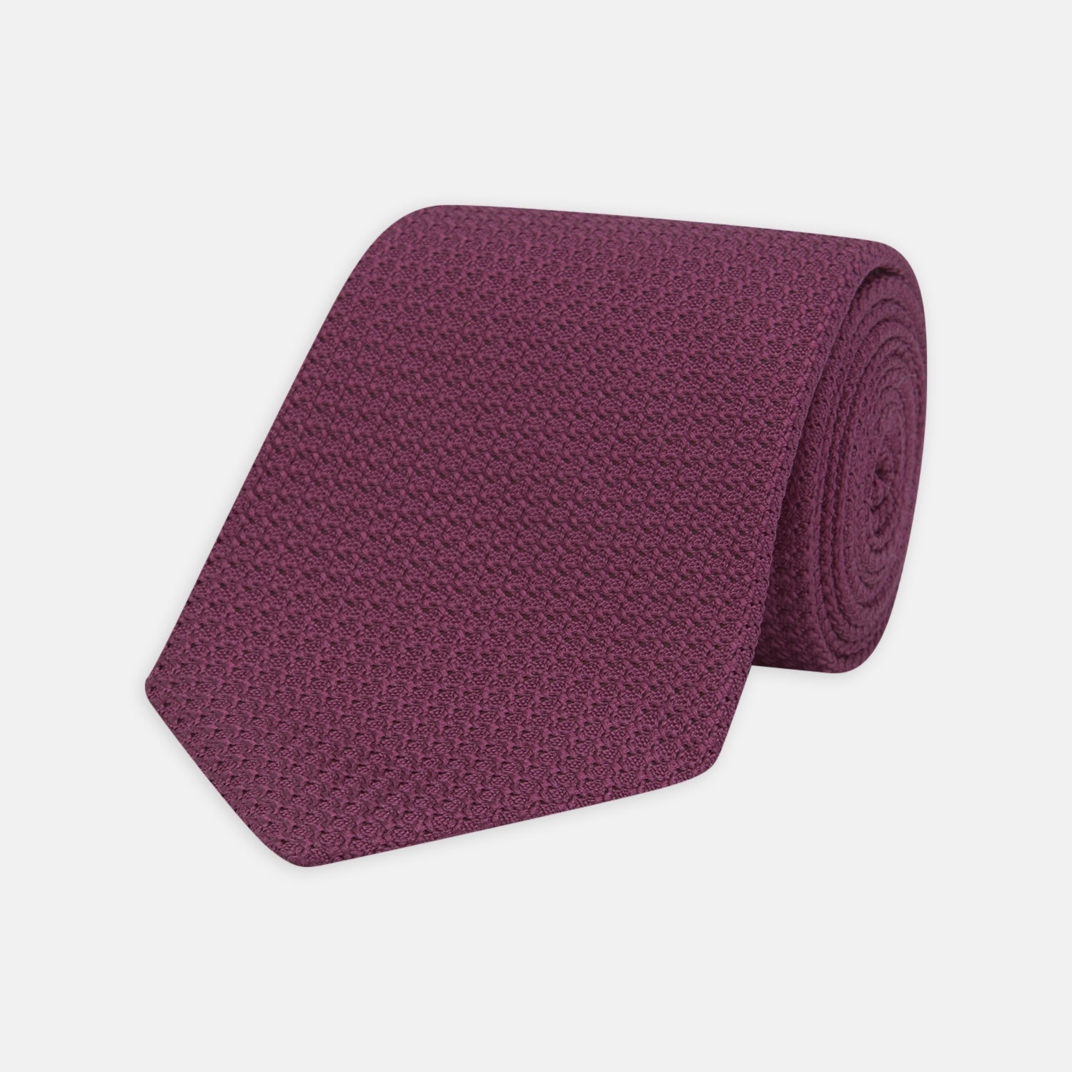 View 1 of product The Turnbull & Asser Wine Grenadine Silk Tie, featuring a textured weave in dark purple, is displayed rolled-up on a plain white background.