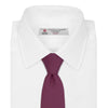 View 2 of product The Turnbull & Asser Wine Grenadine Silk Tie, featuring a textured weave in dark purple, is displayed rolled-up on a plain white background.
