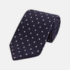 View 1 of product The Seven-Fold Navy Churchill Spot Silk Tie by Turnbull & Asser features evenly spaced white polka dots on navy silk—a luxury neckwear piece rolled up and displayed on a white background.