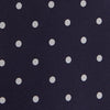 View 3 of product The Seven-Fold Navy Churchill Spot Silk Tie by Turnbull & Asser features evenly spaced white polka dots on navy silk—a luxury neckwear piece rolled up and displayed on a white background.