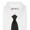 View 2 of product The Turnbull & Asser Black Twill Silk Tie features a subtle textured pattern and is displayed neatly rolled on a plain white background.