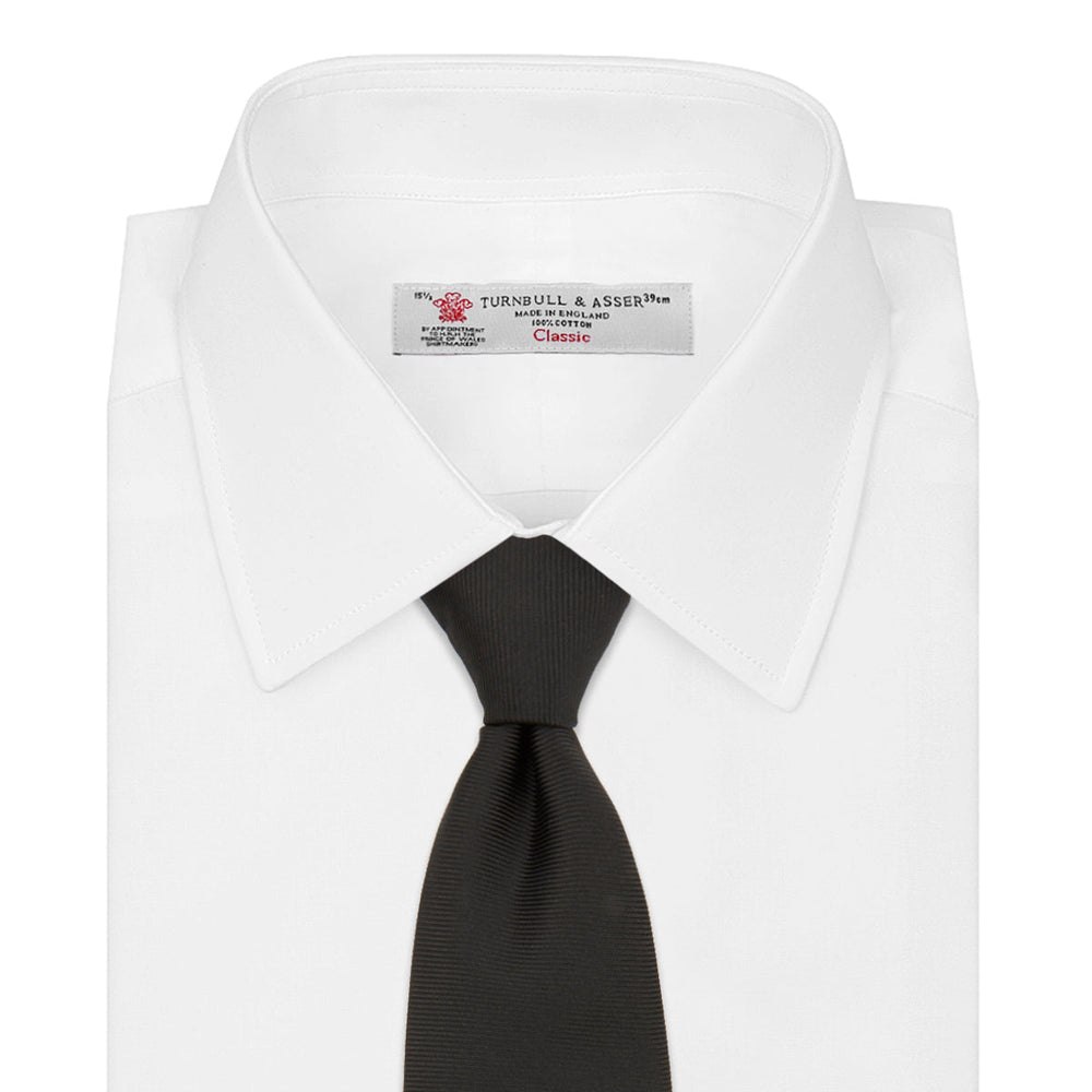 The Turnbull & Asser Black Twill Silk Tie features a subtle textured pattern and is displayed neatly rolled on a plain white background.