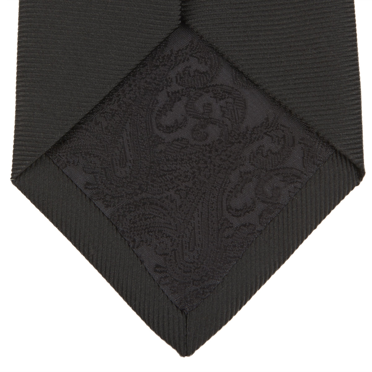 View 4 of product The Turnbull & Asser Slim Black Twill Silk Tie is neatly rolled on a white background, offering an ideal smart finish when paired with cotton shirts.