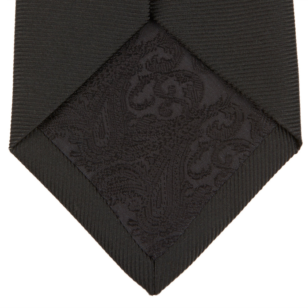 The Turnbull & Asser Black Twill Silk Tie features a subtle textured pattern and is displayed neatly rolled on a plain white background.