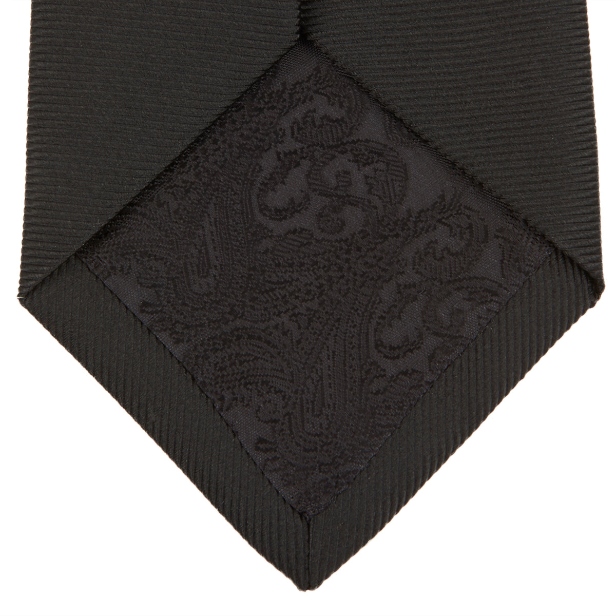 View 4 of product The Turnbull & Asser Black Twill Silk Tie features a subtle textured pattern and is displayed neatly rolled on a plain white background.