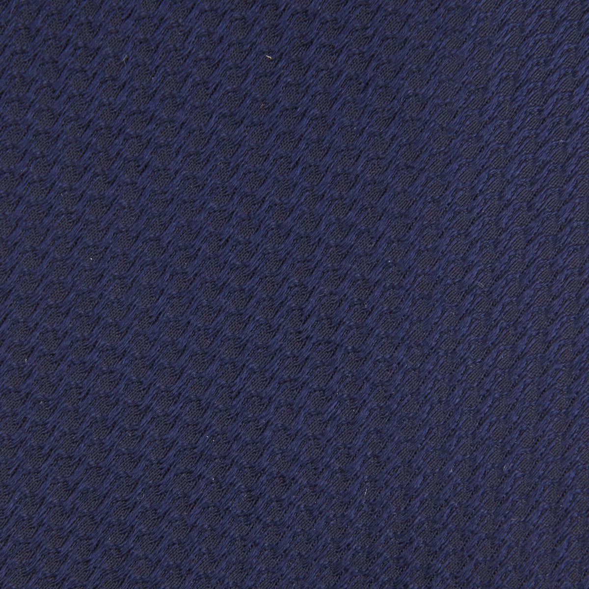 View 3 of product A close-up of the Turnbull & Asser Long Navy Lace Silk Tie, featuring a subtle lace weave texture, rolled up and displayed on a plain white background.