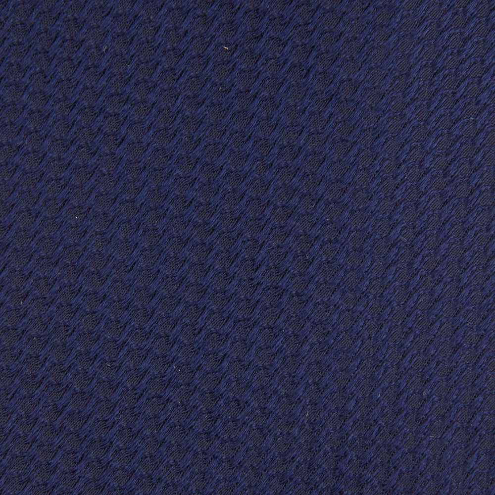 The Turnbull & Asser Navy Lace Silk Tie, featuring a subtle lace weave texture, is displayed rolled up on a plain white background.