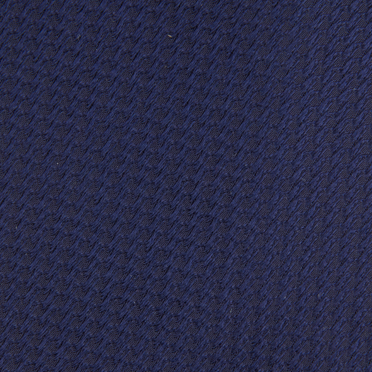 View 3 of product The Turnbull & Asser Navy Lace Silk Tie, featuring a subtle lace weave texture, is displayed rolled up on a plain white background.