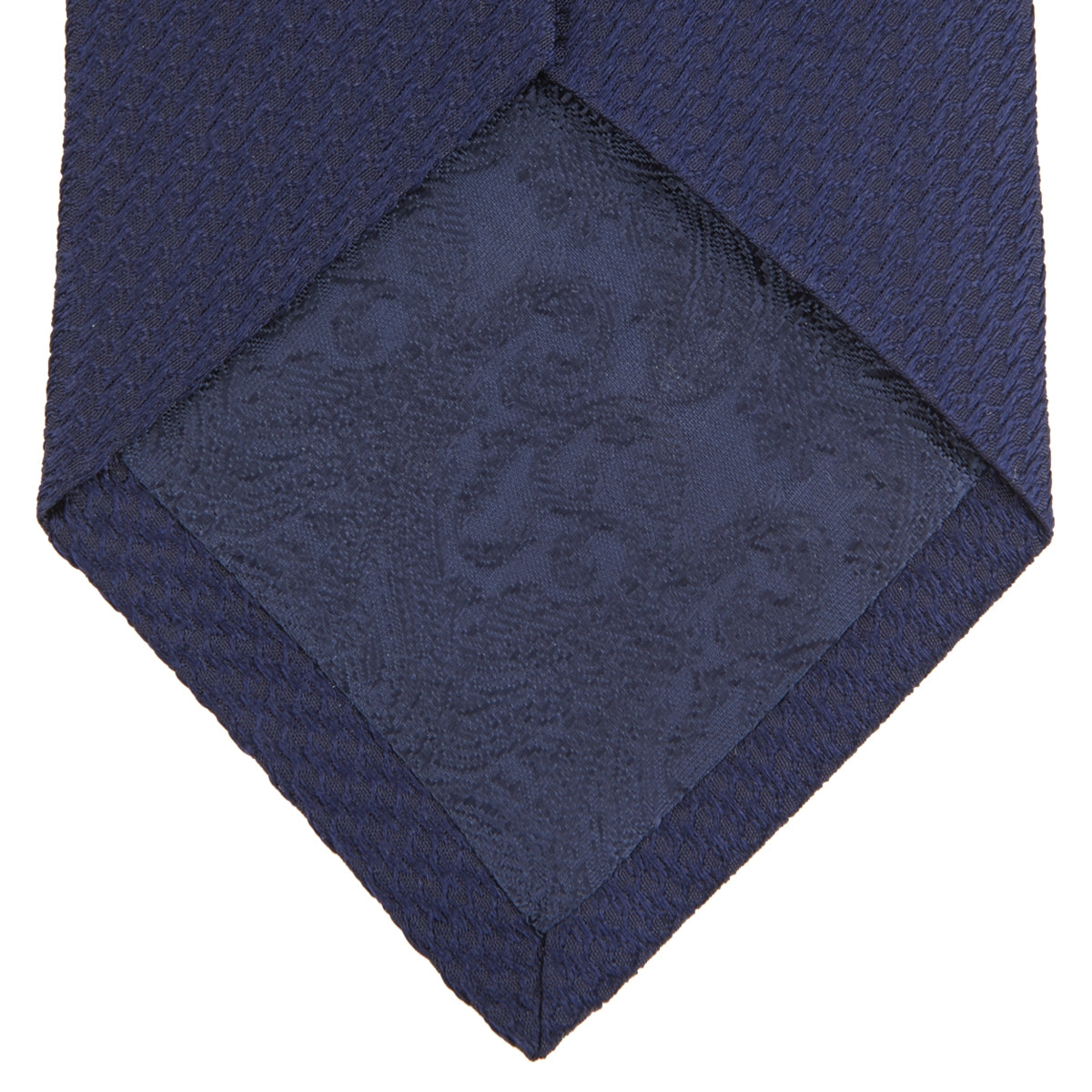 View 4 of product A close-up of the Turnbull & Asser Long Navy Lace Silk Tie, featuring a subtle lace weave texture, rolled up and displayed on a plain white background.