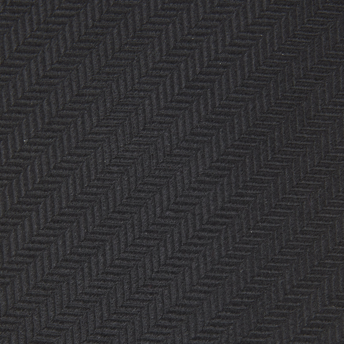 View 3 of product The Turnbull & Asser Seven-Fold Black Herringbone Silk Tie, featuring a subtle weave, is shown rolled up against a plain white background.