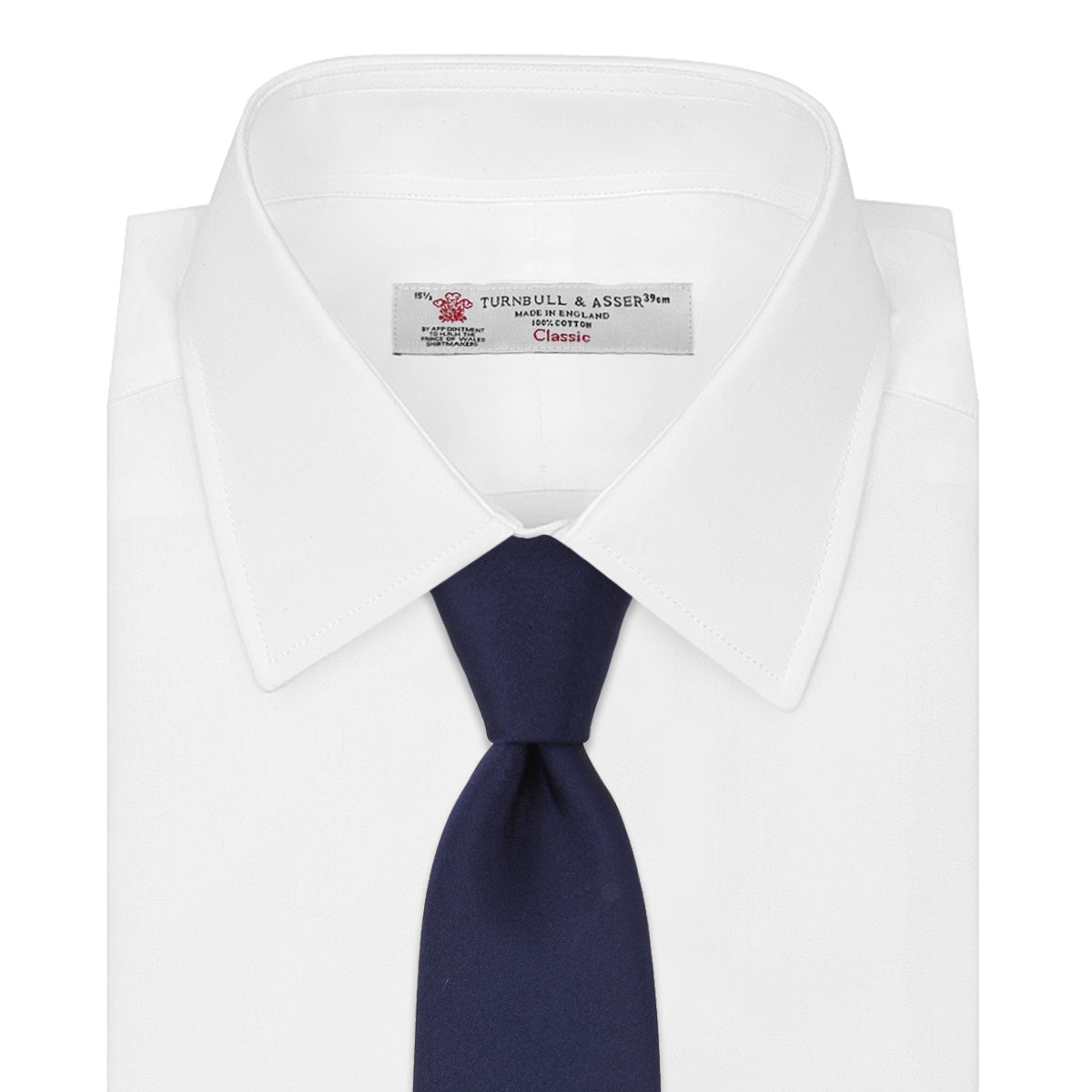 View 2 of product The Turnbull & Asser Seven-Fold Navy Plain Satin Silk Tie is neatly rolled and showcased against a plain light gray background.
