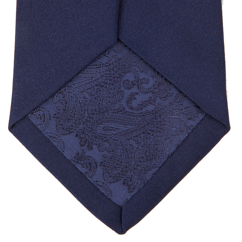 The Turnbull & Asser Navy Plain Satin Silk Tie is neatly rolled and set against a white background, making it an ideal accessory for smart dress occasions.