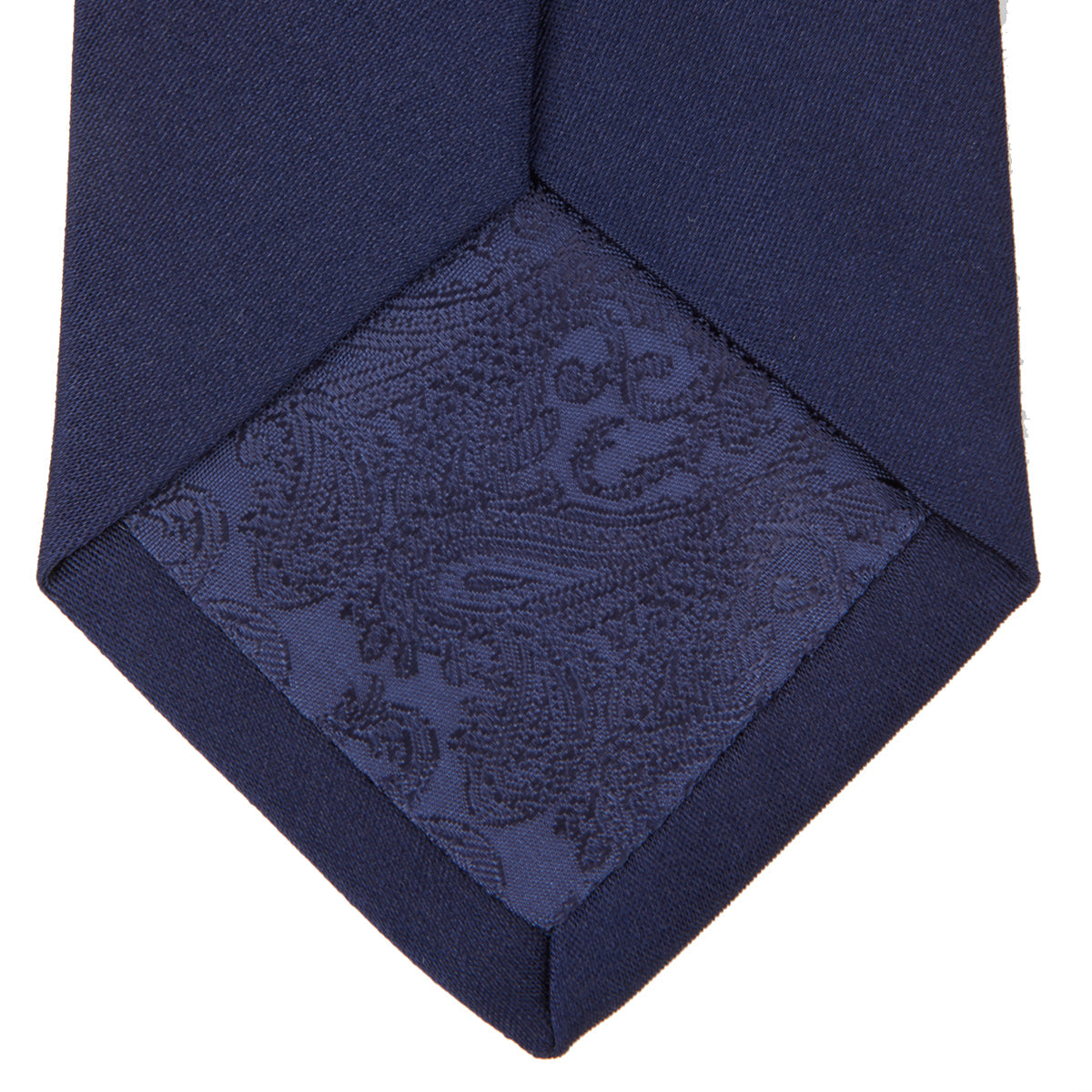 View 4 of product The Turnbull & Asser Navy Plain Satin Silk Tie is neatly rolled and set against a white background, making it an ideal accessory for smart dress occasions.