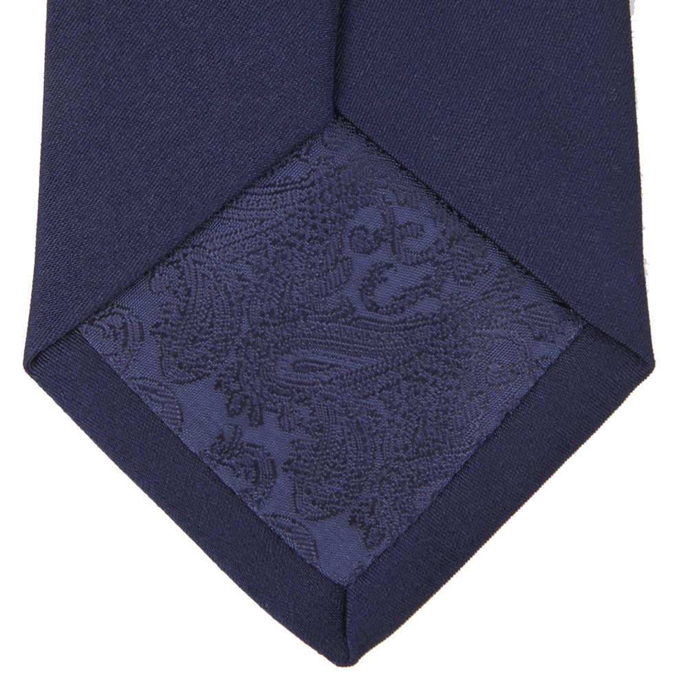 The Turnbull & Asser Slim Navy Plain Satin Silk Tie, crafted from smooth silk in a deep blue shade, is an elegant accessory ideal for smart dressing.