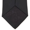 View 4 of product The Turnbull & Asser Slim Black Plain Satin Silk Tie is neatly rolled on a white background—an essential accessory for smart dress and formal occasions.