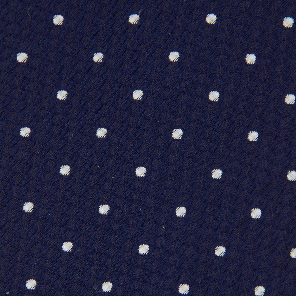 The Turnbull & Asser Navy and White Spot Lace Silk Tie features evenly spaced small white polka dots—perfect for adding a classic touch to any office shirt.