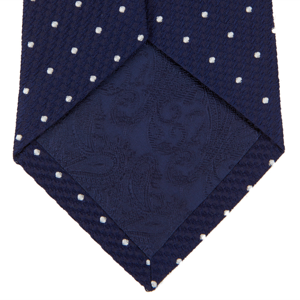 The Turnbull & Asser Navy and White Spot Lace Silk Tie features evenly spaced small white polka dots—perfect for adding a classic touch to any office shirt.