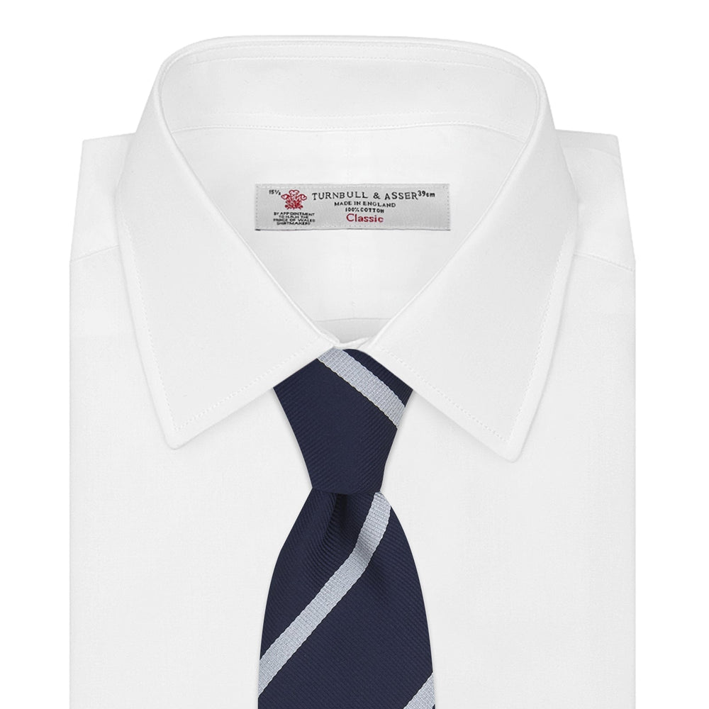 Turnbull & Asser’s Slim Navy and White Blazer Stripe Repp Silk Tie features two white diagonal stripes, rolled neatly on a white background—an ideal accessory to complement any office shirt.