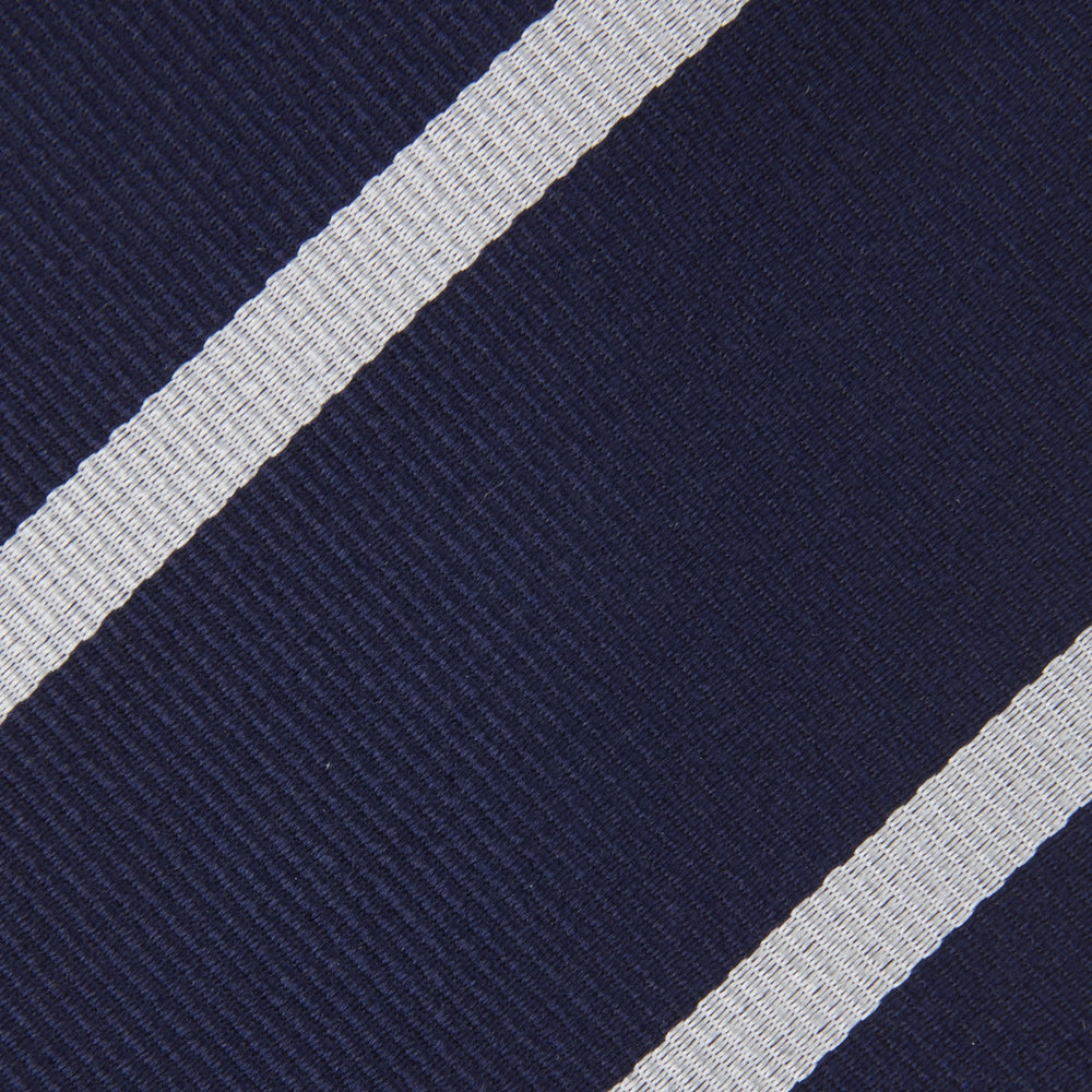 The Turnbull & Asser Long Navy and White Blazer Stripe Repp Silk Tie is shown rolled at one end, highlighting its diagonal stripes, against a plain white background.