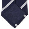 View 3 of product The Turnbull & Asser Long Navy and White Blazer Stripe Repp Silk Tie is shown rolled at one end, highlighting its diagonal stripes, against a plain white background.
