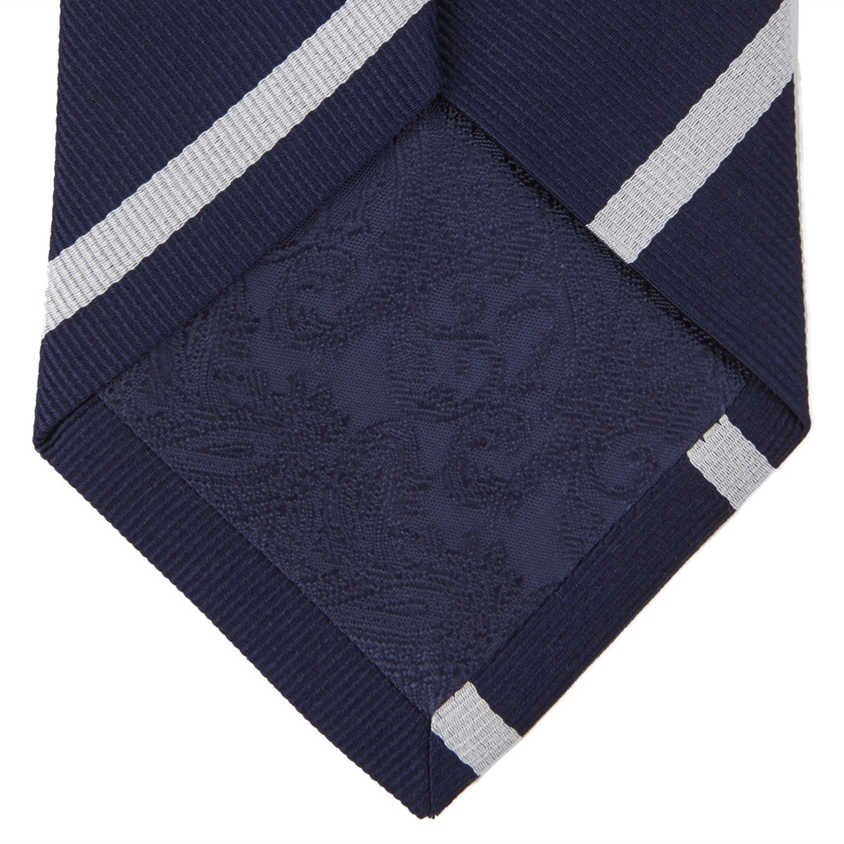 View 3 of product The Turnbull & Asser Long Navy and White Blazer Stripe Repp Silk Tie is shown rolled at one end, highlighting its diagonal stripes, against a plain white background.