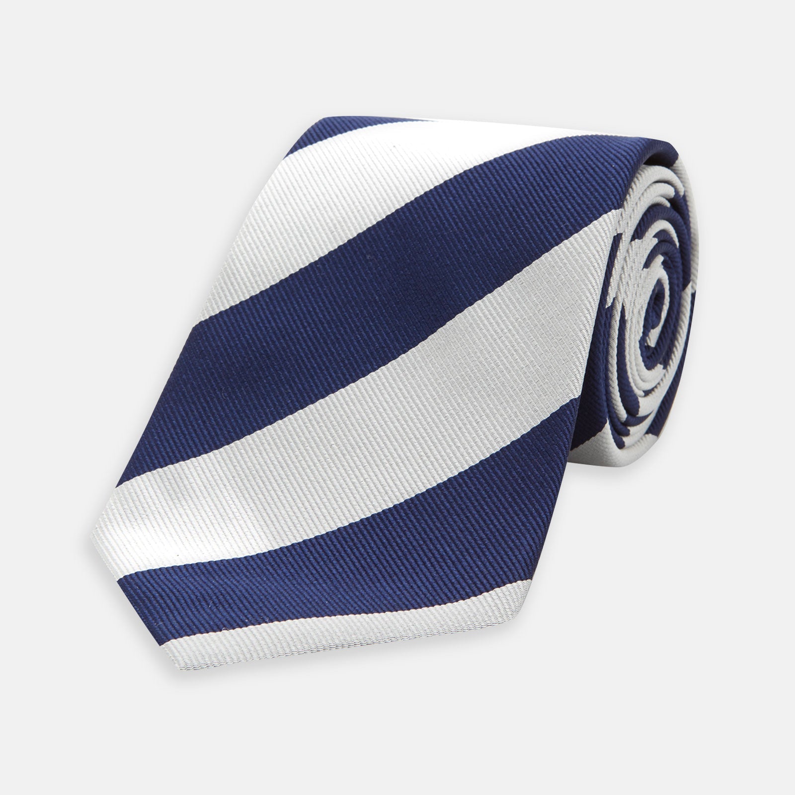 View 1 of product The Turnbull & Asser Navy and Off-White Block Stripe Repp Silk Tie features wide diagonal stripes, ideal for pairing with an office shirt against a plain light background.
