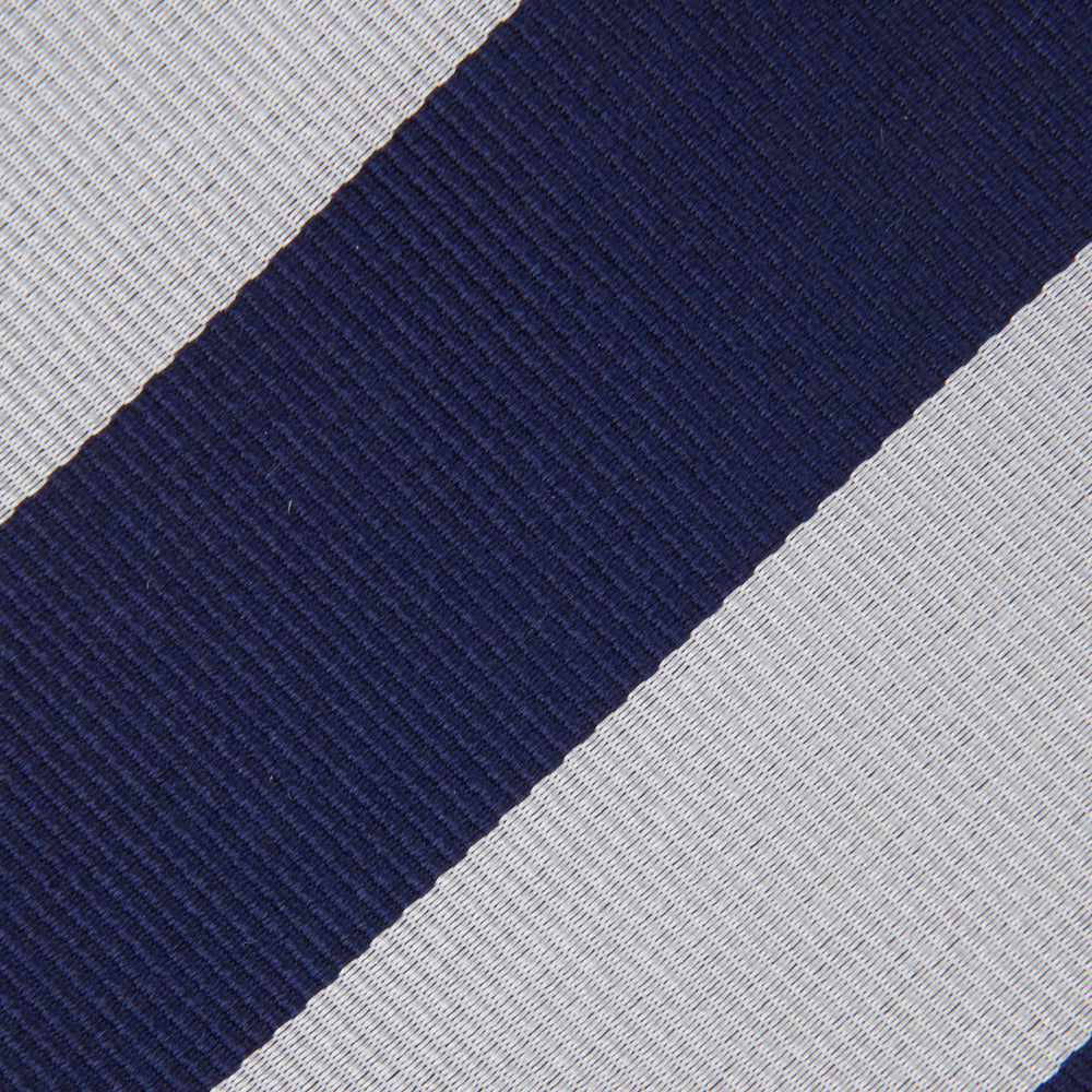 The Turnbull & Asser Navy and Off-White Block Stripe Repp Silk Tie features wide diagonal stripes, ideal for pairing with an office shirt against a plain light background.