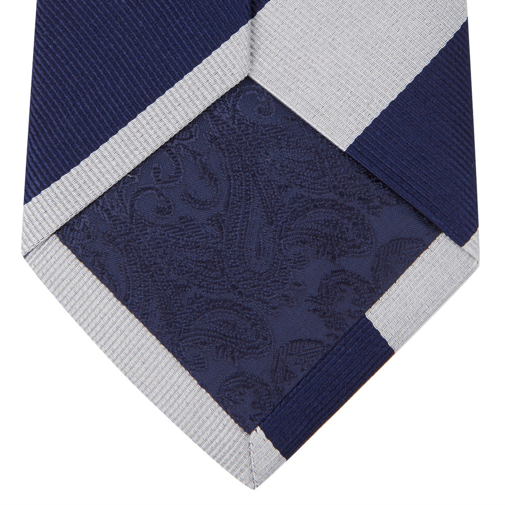 The Turnbull & Asser Navy and Off-White Block Stripe Repp Silk Tie features wide diagonal stripes, ideal for pairing with an office shirt against a plain light background.
