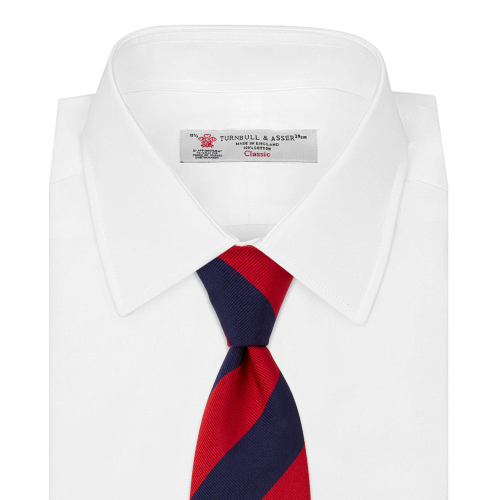 The Navy and Red Block Stripe Repp Silk Tie by Turnbull & Asser features bold diagonal red and navy stripes on a crisp white background.