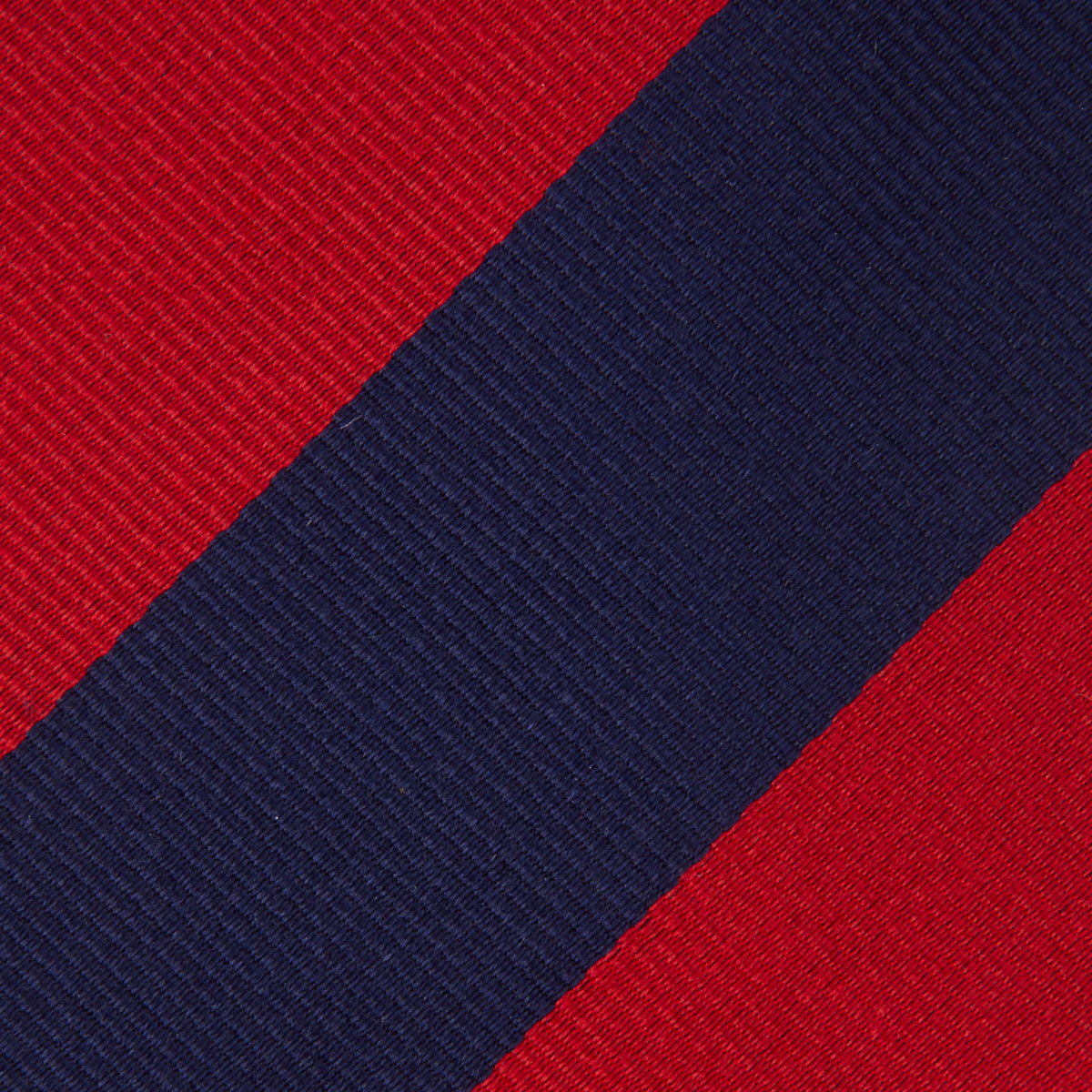 View 3 of product The Navy and Red Block Stripe Repp Silk Tie by Turnbull & Asser features bold diagonal red and navy stripes on a crisp white background.