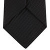 View 4 of product The Black Ottoman Silk Tie by Turnbull & Asser features a subtle wavy textured pattern and is crafted from heavyweight ribbed silk, shown rolled up against a plain white background.