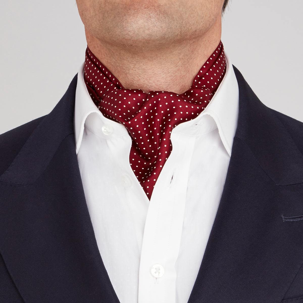 View 2 of product The Burgundy and White Mini Spot Silk Cravat by Turnbull & Asser adds refined detail—ideal neckwear for wedding guests, especially paired with a matching maroon pocket square.