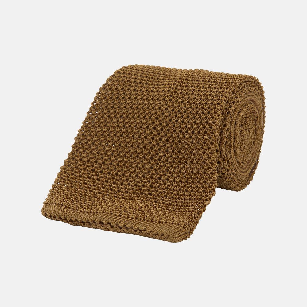 The Gold Knitted Silk Tie by Turnbull & Asser, featuring a textured pattern, is elegantly displayed on a plain white background.