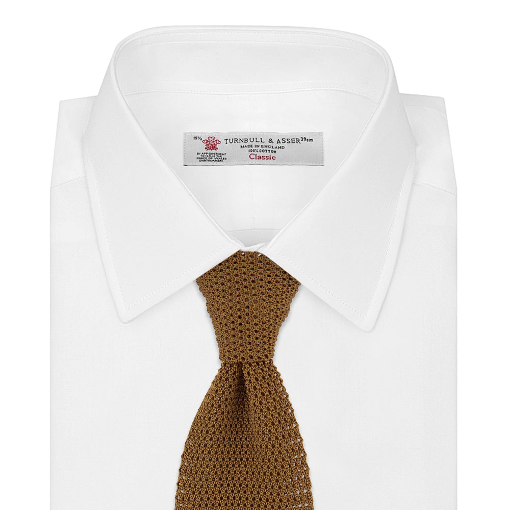 The Gold Knitted Silk Tie by Turnbull & Asser, featuring a textured pattern, is elegantly displayed on a plain white background.