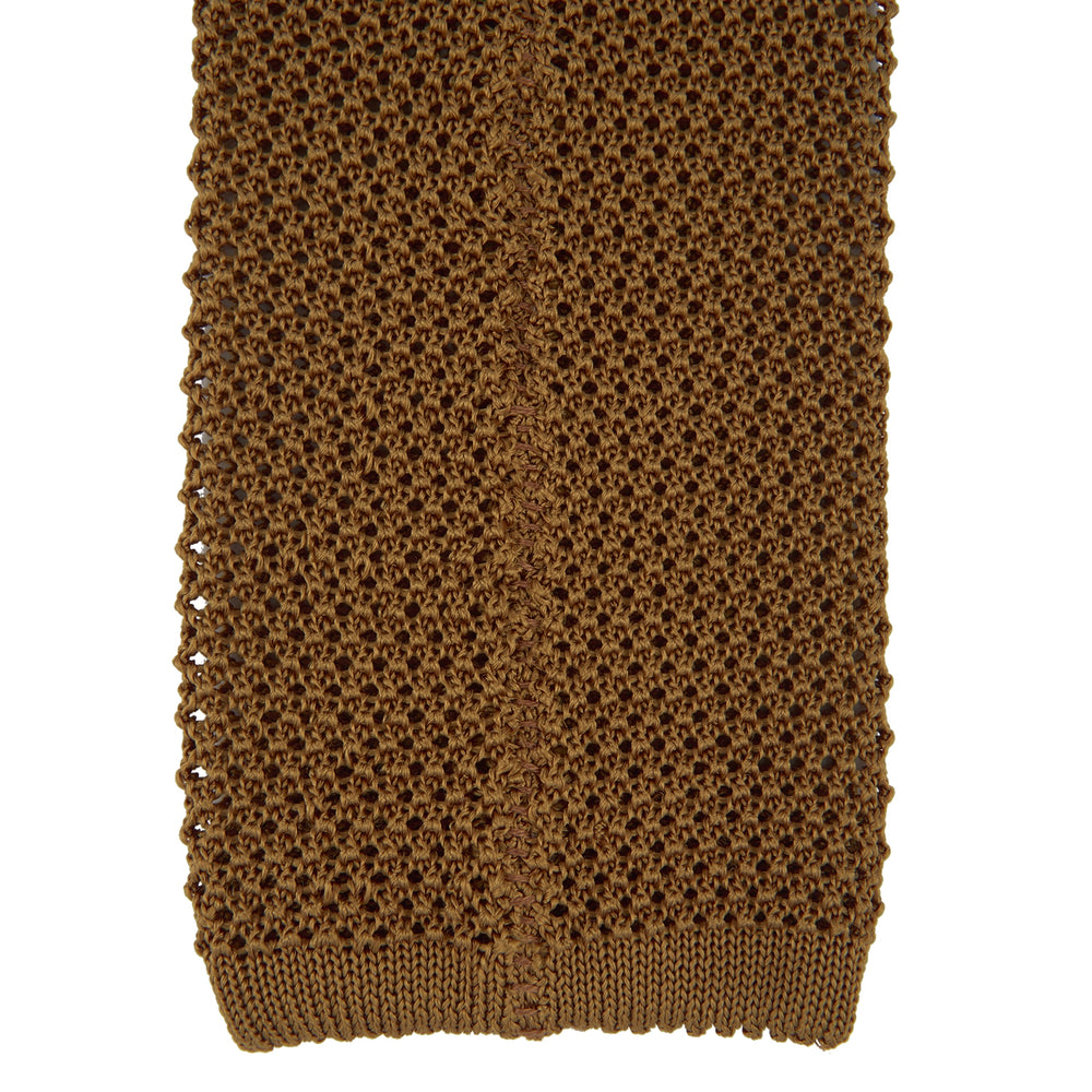 The Gold Knitted Silk Tie by Turnbull & Asser, featuring a textured pattern, is elegantly displayed on a plain white background.
