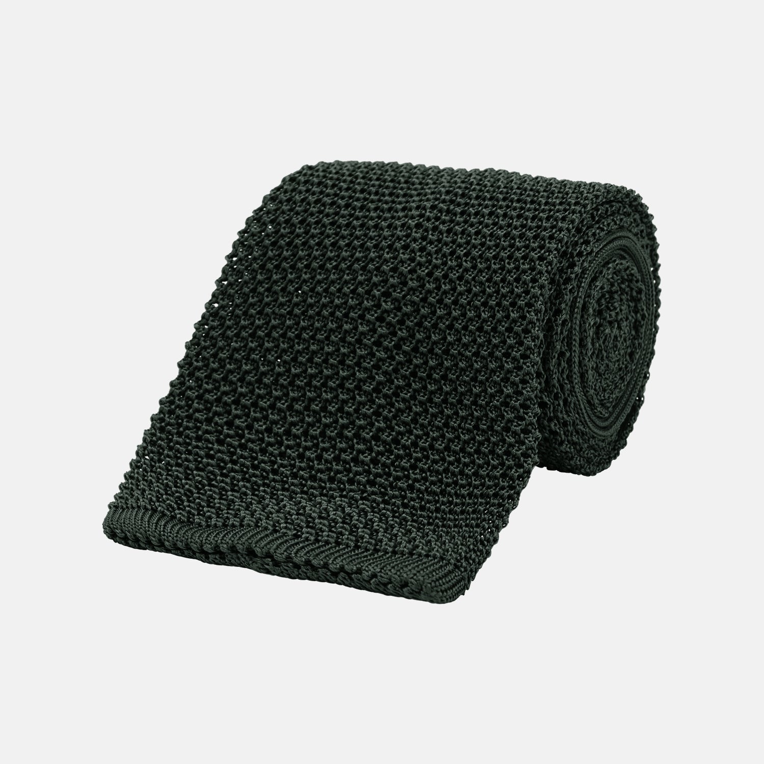 View 1 of product The Turnbull & Asser Green Knitted Silk Tie features a rich dark green hue and textured weave, making it an elegant accessory for any gentleman's wardrobe, shown rolled up against a light background.